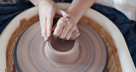 Image showing Pottery, art and hands on a potter wheel with artist spinning clay in creative class, workshop or studio. Creativity, handicraft and closeup of a sculptor working on ceramic design, craft or creation