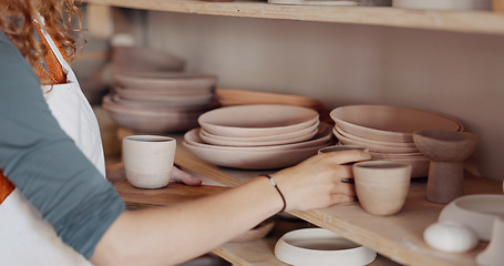 Image showing Pottery woman, shelf and creative ceramic cups with artist or craft person standing in artisan workshop or art studio. Entrepreneur potter female enjoy hobby making art to sell in startup business