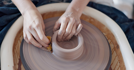 Image showing Pottery, art and hands on a potter wheel with artist spinning clay in creative class, workshop or studio. Creativity, handicraft and closeup of a sculptor working on ceramic design, craft or creation