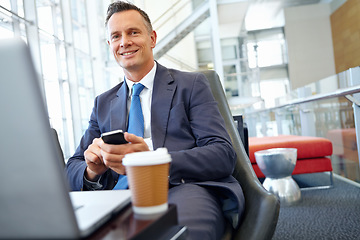 Image showing Businessman smile, laptop and smartphone with company communication or social media with coffee while working. Contact, online and email with networking and worker in professional corporate lounge