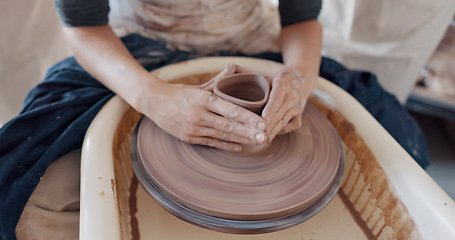 Image showing Pottery, art and hands on a potter wheel with artist spinning clay in creative class, workshop or studio. Creativity, handicraft and closeup of a sculptor working on ceramic design, craft or creation