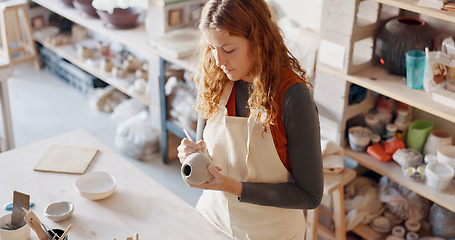 Image showing Pottery, art and design woman artist in a home studio working on creative work. Ceramic arts designer or student at a learning workshop or house preparing a clay stencil pattern on a vase project