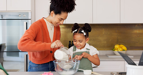 Image showing Family, children and baking with a woman and girl cooking in the kitchen of their home together. Food, taste and love with a mother and daughter adding ingredients to a bowl while preparing a dessert