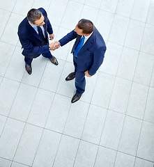 Image showing Top view, business people or handshake in modern office, finance company or investment startup for insurance deal. Men, shaking hands or partnership gesture for corporate workers in welcome greeting