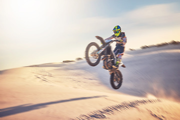 Image showing Motorcycle, athlete and sports outdoor with jump stunt, fitness in desert and extreme sport with speed and freedom. Challenge, power and biking with exercise, person training and dirt bike rally