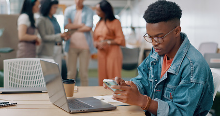 Image showing Phone, laptop and creative man in the office networking on social media, mobile app and the internet. Technology, planning and African male marketing employee doing research and working on a project.