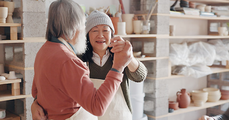 Image showing Pottery, creative and senior couple talking about art dancing together in a studio class. Elderly Asian man and woman hugging with love while learning and working with clay on a date