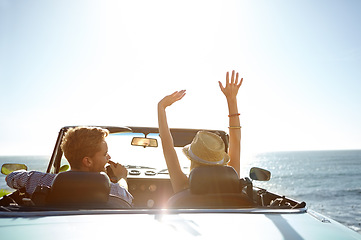 Image showing Car, road trip and travel with a couple by the beach on a drive to enjoy the view during summer together. Freedom, transport and driver with a woman sitting hands raised by the ocean with her man