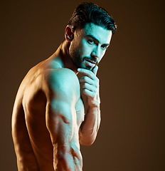 Image showing Sexy, muscular and portrait of a man in a studio with a hot, sensual and attractive pose. Seductive, handsome and young strong male model with biceps, body and muscles posing by a brown background.