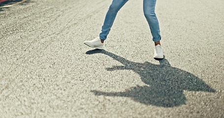 Image showing Feet, dancing and woman in city street for celebration, achievement or happy success with shadow or silhouette on asphalt road. Energy, freedom and urban hip hop dancer student girl legs and sneakers