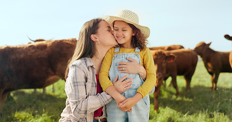 Image showing Farming, child and mother with kiss on a farm during holiday in Spain for sustainability with cattle. Portrait of happy, smile and travel mom and girl with love while on vacation on land with cows