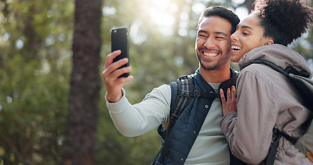 Image showing Hiking, walking and young couple in forest on adventure, journey and exploring nature. Asian man and black woman trekking, walk and taking selfie in woods on smartphone enjoying freedom on weekend