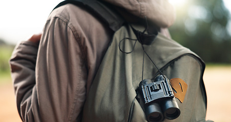 Image showing Traveler, bag and adventure walk to explore, sightsee or scout trip in the outdoors of nature. Closeup of adventurer walking for backpacking, travel or tour with binoculars in the natural environment