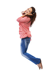 Image showing Music headphones, portrait and woman jump in studio isolated on a white background mock up. Jumping, energy and happy female with hifi headset streaming, listening or enjoying podcast, radio or audio