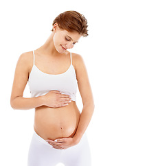 Image showing Pregnancy, love and woman holding her stomach in a studio for prenatal care, motherhood and happiness. Maternity, health and happy pregnant female model embracing her tummy by a white background.