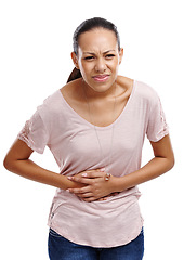 Image showing Woman in a studio with stomach pain, injury or sickness from indigestion or constipation. Discomfort, uncomfortable and female model with a menstrual tummy ache or sore isolated by a white background