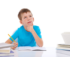 Image showing Young boy, writing and thinking with books at desk for school, education study and student knowledge. Paper, working and child focus for learning, creative drawing or creativity idea vision in studio