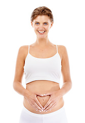 Image showing Pregnancy, portrait and mom with a heart on her stomach in a studio for prenatal care, love and happiness. Wellness, health and happy pregnant female model holding her tummy by a white background.