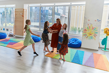 Image showing A child hugging a teacher in a modern kindergarten