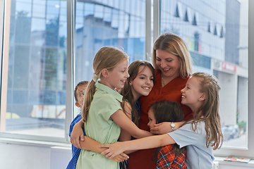 Image showing A child hugging a teacher in a modern kindergarten