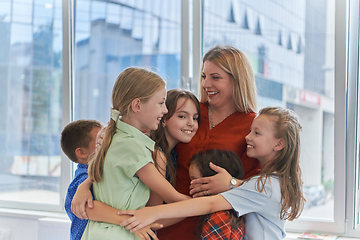 Image showing A child hugging a teacher in a modern kindergarten