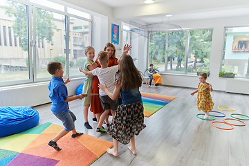 Image showing A child hugging a teacher in a modern kindergarten