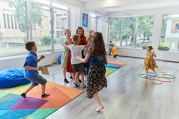 Image showing A child hugging a teacher in a modern kindergarten