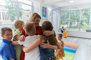 Image showing A child hugging a teacher in a modern kindergarten