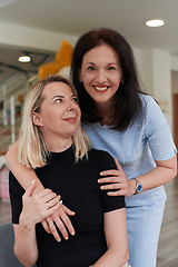 Image showing Two women share a heartfelt embrace while at a preschool, showcasing the nurturing and supportive environment for learning and growth