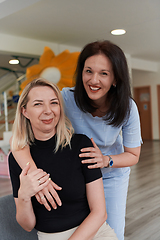 Image showing Two women share a heartfelt embrace while at a preschool, showcasing the nurturing and supportive environment for learning and growth