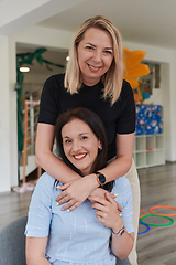 Image showing Two women share a heartfelt embrace while at a preschool, showcasing the nurturing and supportive environment for learning and growth