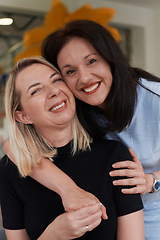 Image showing Two women share a heartfelt embrace while at a preschool, showcasing the nurturing and supportive environment for learning and growth