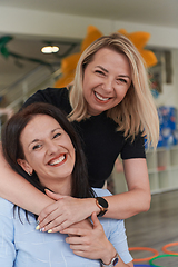 Image showing Two women share a heartfelt embrace while at a preschool, showcasing the nurturing and supportive environment for learning and growth