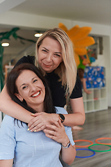 Image showing Two women share a heartfelt embrace while at a preschool, showcasing the nurturing and supportive environment for learning and growth