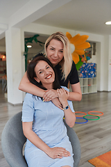 Image showing Two women share a heartfelt embrace while at a preschool, showcasing the nurturing and supportive environment for learning and growth