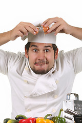 Image showing young funny chef cracking an egg