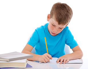 Image showing Young boy, writing and learning homework at desk for school, education and student knowledge. Paper, working and child with books for study, creative drawing or academic preschool practice in studio