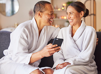 Image showing Senior couple, phone and relax spa wellness on sofa, beauty center and luxury body care or streaming video online. Happiness, woman and man smile together for love with smartphone and therapy gown