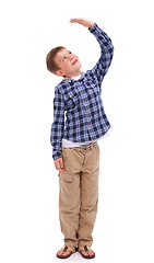 Image showing Children, growth and mockup with a boy measuring his height in studio isolated on a white background. Kids, hand and wall with a male child growing up to be tall on blank space for development