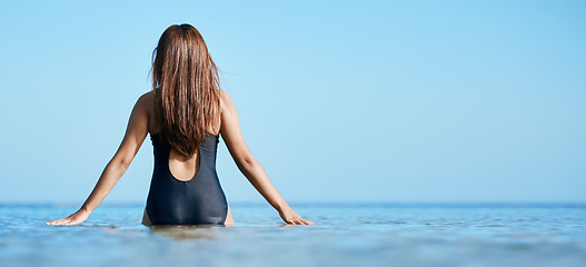 Image showing Back, young woman swimming at the beach on vacation in Mauritius and horizon of blue ocean water in summer. Calm female tourist in sea, freedom of travel lifestyle or relaxing on coastal destination