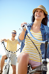 Image showing Cycling, travel and couple with a woman on summer vacation or holiday riding on the promenade by the beach. Bike, freedom and date with a girlfriend outdoor for a ride on the coast during the day