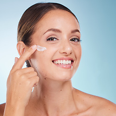 Image showing Skincare, beauty and portrait of a woman with face cream for health, wellness and natural face routine. Cosmetic, happy and model with facial lotion, spf or creme isolated by a blue studio background