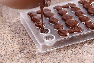 Image showing Baker pours chocolate