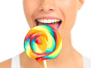 Image showing Candy, lollipop and sweets with a woman in studio isolated on a white background eating a sweet snack. Food, bright or color with a young female holding and licking a giant lolly closeup alone