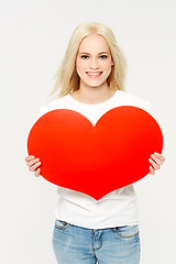 Image showing Love, portrait and woman in studio with paper heart, sign and emoji against white background. Face, shape and girl showing care, affection and self love, happy and content, young and isolated space