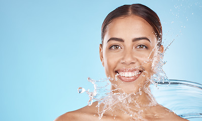 Image showing Happy woman, face skincare or water splash on blue background studio in healthcare wellness, hygiene maintenance or grooming mockup. Smile portrait, beauty model and facial water drop in wet cleaning