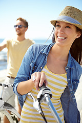 Image showing Bike, travel and couple with a woman on summer vacation or holiday riding on the promenade by the beach. Freedom, date and romance with a girlfriend outdoor for a ride on the coast during the day