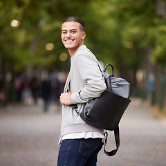 Image showing Student portrait and university man travel commute in park with backpack and optimistic smile. Happy, youth and gen z college learner smiling while commuting in New York, USA with bokeh lights