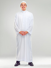 Image showing Islamic man, religion fashion and standing for worship, prayer or spiritual happiness in white background. Arabic person, smile and happy respect for muslim culture or clothes isolated in studio