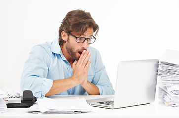 Image showing Laptop, paperwork and shocked businessman working on a project with a deadline in a studio. Shock, surprise and professional male employee with a computer and corporate documents by white background.